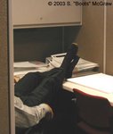 A co-worker is caught asleep at his desk during lunch hour. This particular employee can't keep his feet in his shoes during the day. I make excuses to walk by his cubicle and sneak a peek.